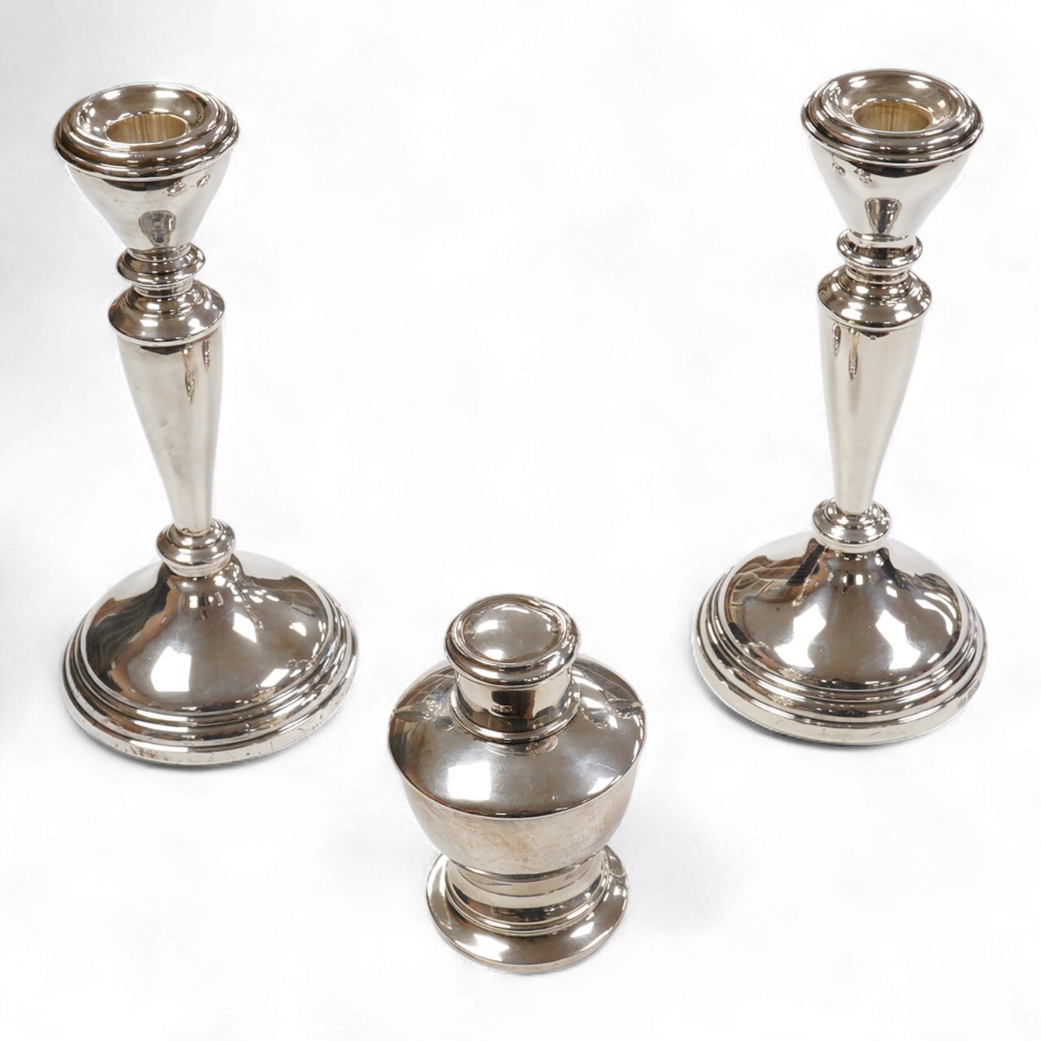 A pair of Elizabeth II silver candlesticks, Elkington & Co, Birmingham, 1965, height 19cm, weighted and a George V small silver tea caddy.